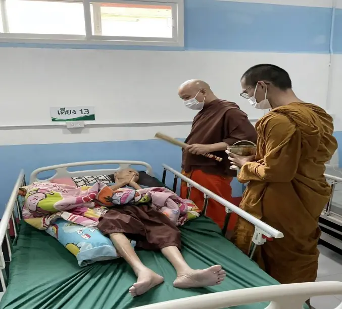 พระสงฆ์และเจ้าหน้าที่ดูแลพระอาพาธบนเตียงผู้ป่วย